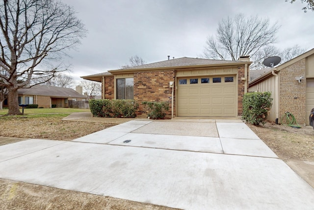 view of front of property with brick siding, driveway, and a garage