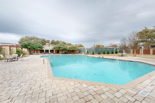 community pool featuring a patio and fence