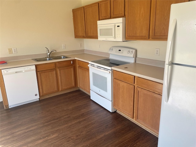 kitchen with white appliances, brown cabinetry, dark wood-style floors, a sink, and light countertops