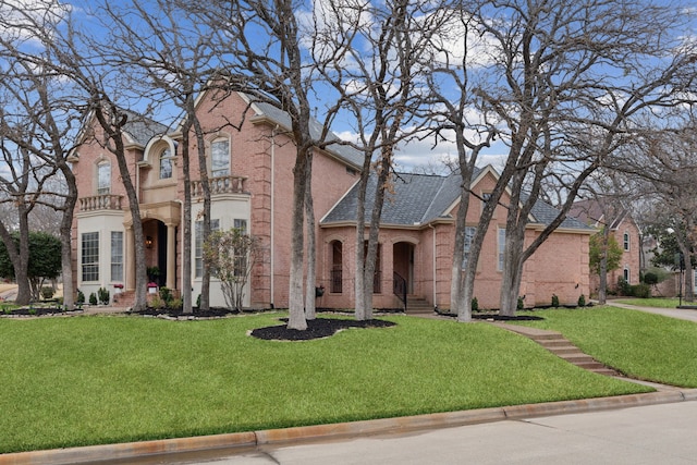 view of front of house featuring brick siding and a front yard