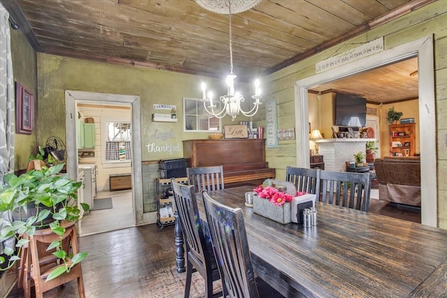 dining space featuring dark wood finished floors, an inviting chandelier, and wood ceiling