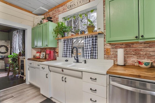 kitchen with light wood-style flooring, a sink, brick wall, green cabinetry, and dishwasher