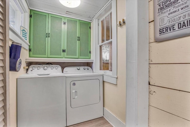 laundry room with washer and dryer, cabinet space, and light wood-style flooring