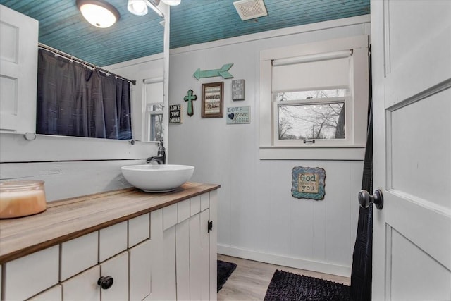 full bathroom featuring visible vents, curtained shower, wood finished floors, and vanity