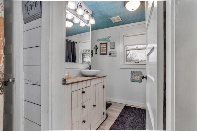 bathroom with vanity, wood finished floors, visible vents, and baseboards