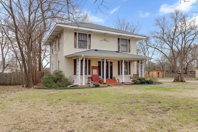 view of front facade featuring covered porch, stucco siding, a front yard, and fence