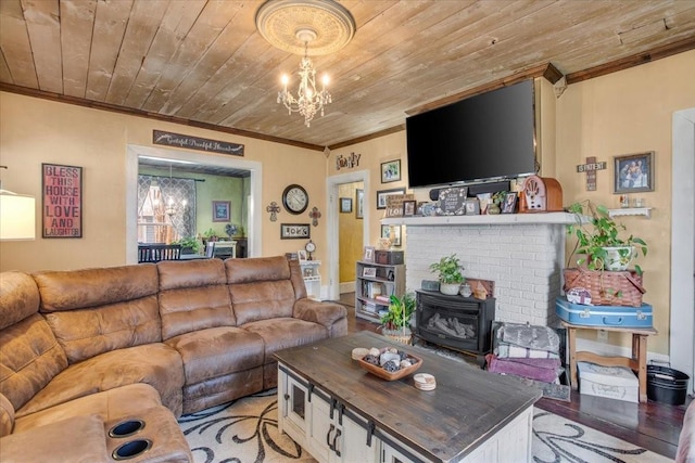 living room featuring a wood stove, a notable chandelier, ornamental molding, and wooden ceiling