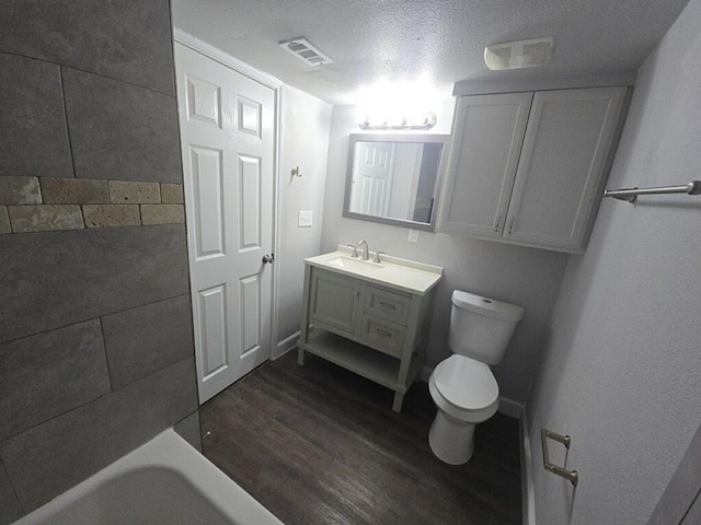 full bathroom featuring vanity, wood finished floors, visible vents, a tub, and toilet