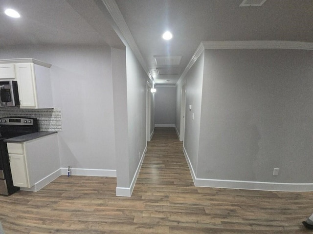 corridor with recessed lighting, ornamental molding, baseboards, and dark wood-style flooring