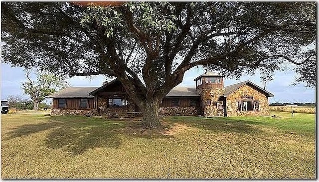 view of front of property featuring a front yard and stone siding