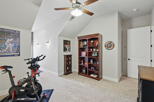 workout area with vaulted ceiling, light colored carpet, baseboards, and ceiling fan