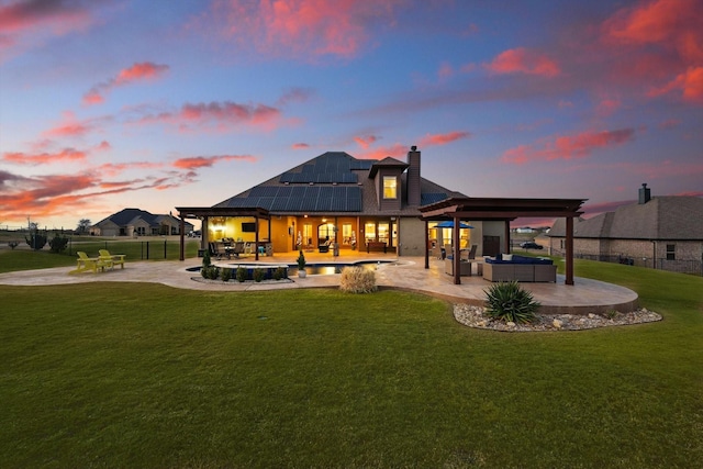 back of house featuring an outdoor living space, solar panels, fence, a lawn, and a patio area