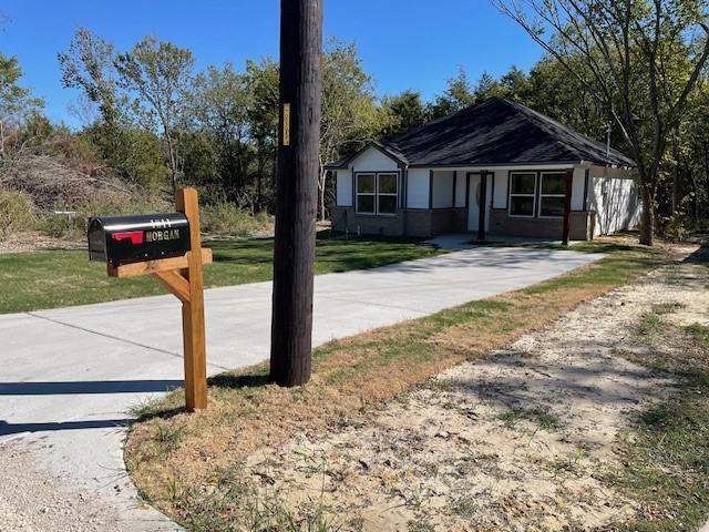 view of front of property featuring a front lawn and concrete driveway