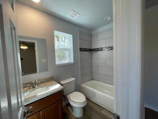 bathroom featuring visible vents, toilet, vanity, and wood finished floors