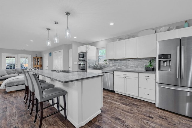 kitchen featuring a healthy amount of sunlight, stainless steel appliances, dark wood-style floors, and a sink