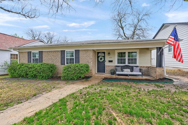 view of front of house with brick siding, outdoor lounge area, and covered porch