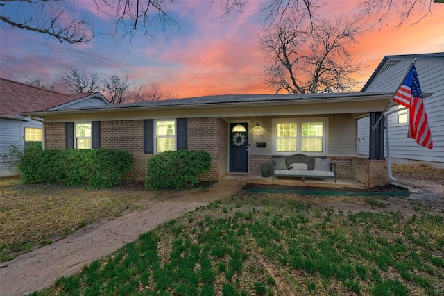 view of front of home featuring brick siding and covered porch