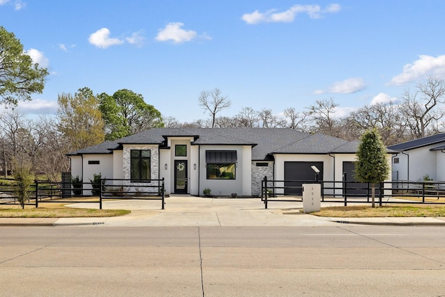 view of front of property with stucco siding, a garage, concrete driveway, and a fenced front yard