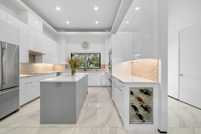 kitchen featuring high end fridge, white cabinets, modern cabinets, and light countertops