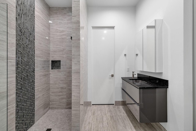 full bathroom featuring vanity and tiled shower