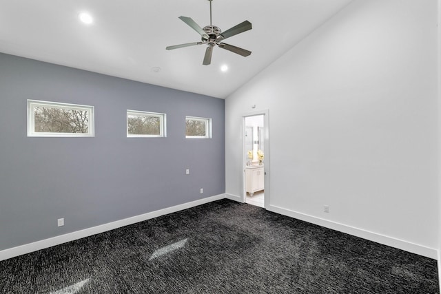 empty room with lofted ceiling, plenty of natural light, baseboards, and dark carpet