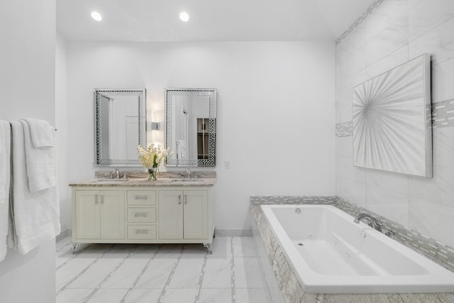 full bath with a sink, a jetted tub, baseboards, and double vanity