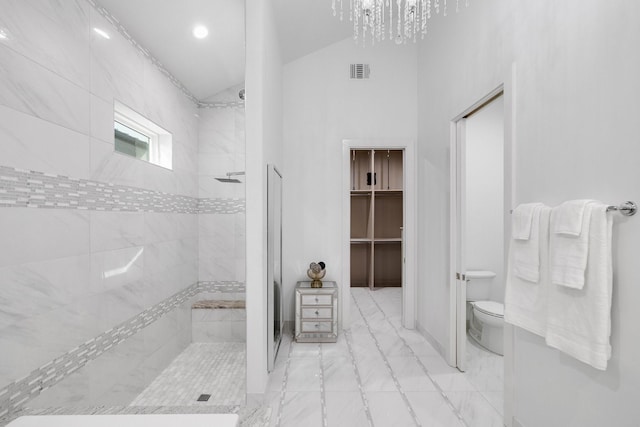 bathroom featuring toilet, visible vents, a tile shower, and a chandelier