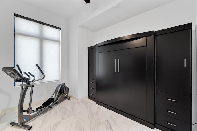 workout area featuring baseboards and marble finish floor