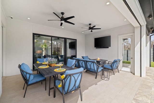 view of patio / terrace featuring an outdoor fire pit, outdoor dining area, and a ceiling fan