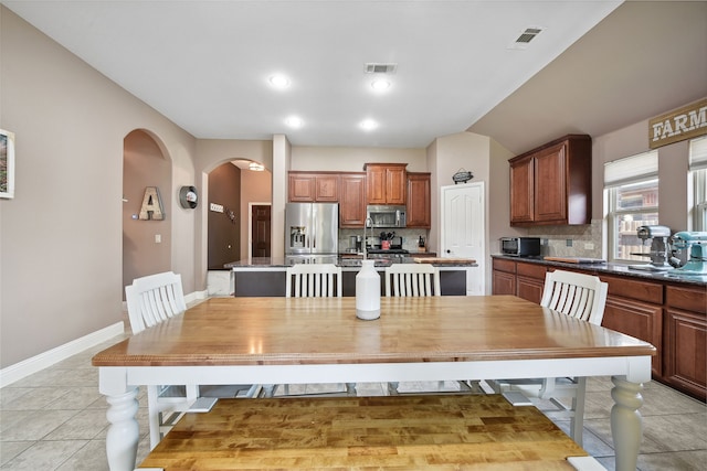 kitchen featuring decorative backsplash, an island with sink, visible vents, and appliances with stainless steel finishes