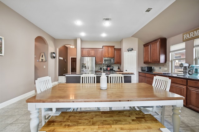 521 Eastbrook Dr, Anna, TX 75409 - dining room with arched walkways, vaulted ceiling, and light tile patterned floors