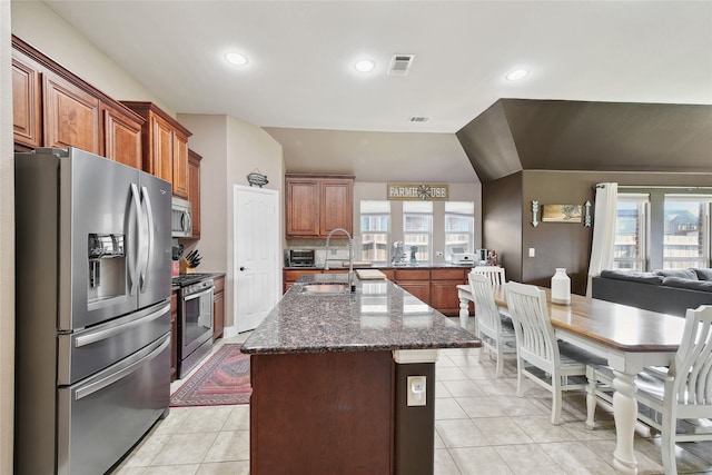 521 Eastbrook Dr, Anna, TX 75409 - kitchen with stainless steel appliances, a kitchen island with sink, light tile patterned floors, dark stone countertops, and recessed lighting