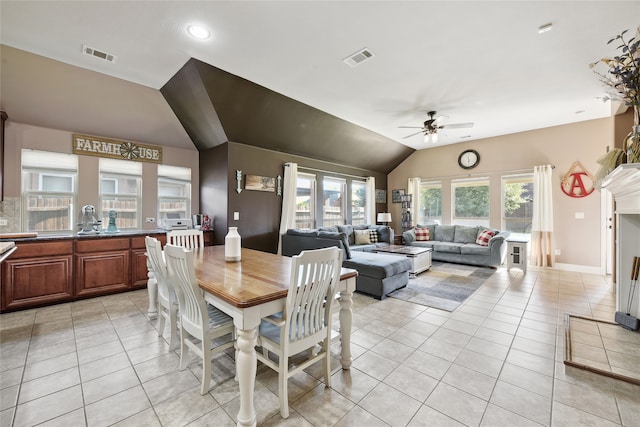 dining space with light tile patterned flooring, visible vents, and vaulted ceiling