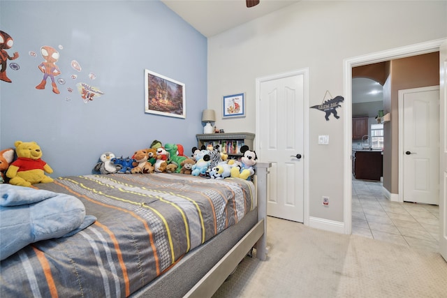 bedroom featuring light carpet, light tile patterned floors, arched walkways, and baseboards