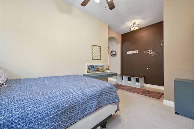 carpeted bedroom with arched walkways, baseboards, and ceiling fan