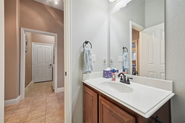 bathroom with baseboards, vanity, and tile patterned flooring