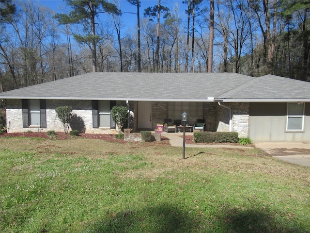 ranch-style house featuring a front yard and roof with shingles