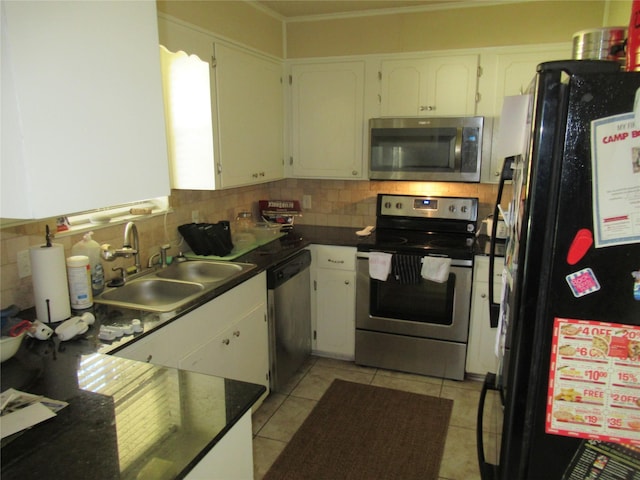 kitchen featuring a sink, dark countertops, white cabinetry, appliances with stainless steel finishes, and decorative backsplash