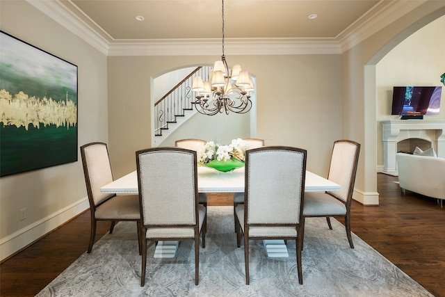 dining room featuring arched walkways, a notable chandelier, wood finished floors, and ornamental molding