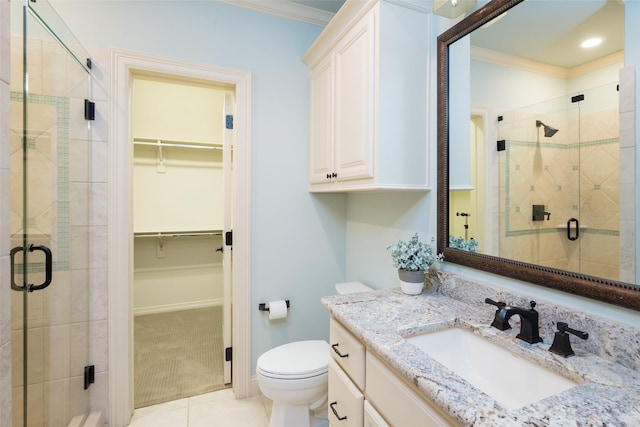 full bathroom featuring a stall shower, toilet, a walk in closet, and ornamental molding