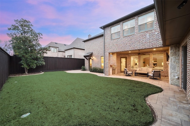 view of yard with an outdoor living space, a fenced backyard, and a patio area