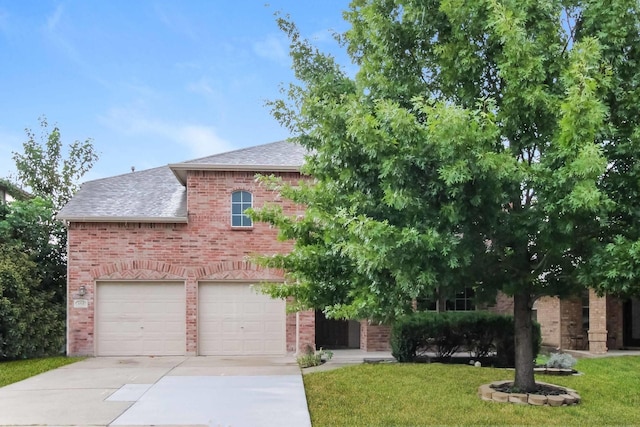 view of front facade with brick siding, a shingled roof, concrete driveway, a front yard, and a garage