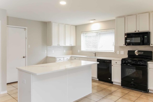 kitchen with black appliances, a center island, light tile patterned floors, white cabinetry, and a sink