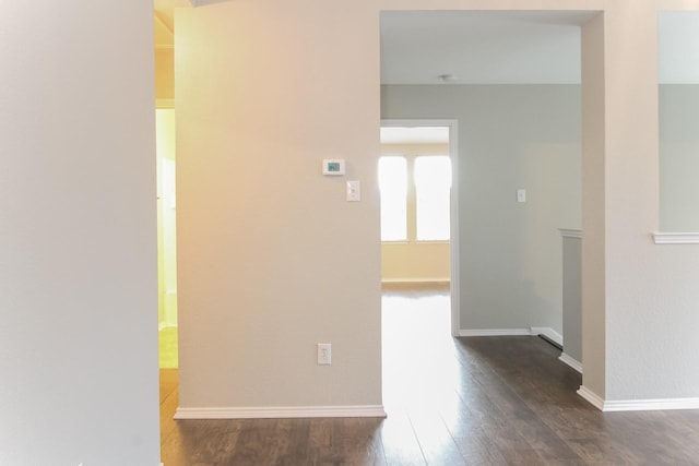 empty room with baseboards and dark wood-style flooring