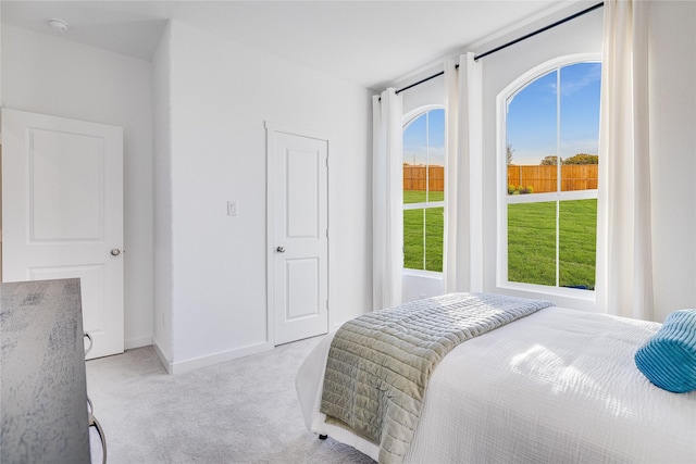 bedroom with light colored carpet and baseboards