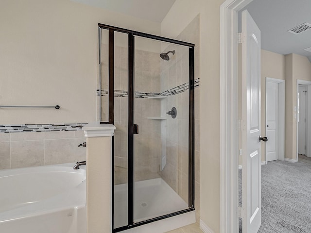 bathroom featuring a garden tub, visible vents, and a stall shower