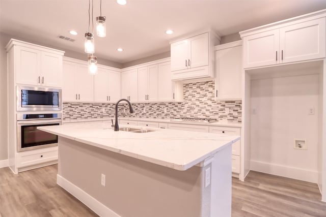 kitchen with light wood-type flooring, visible vents, appliances with stainless steel finishes, and a sink