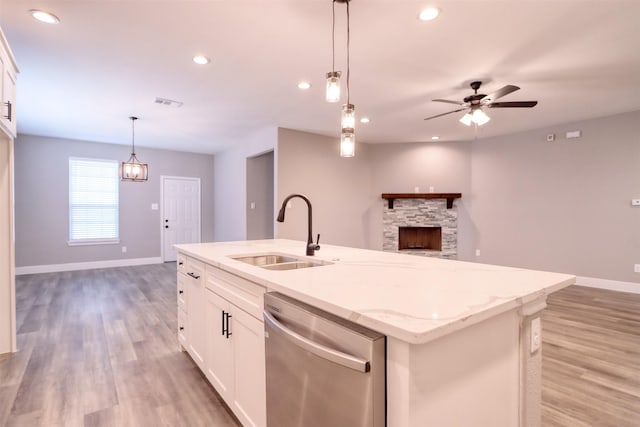 kitchen with pendant lighting, a sink, stainless steel dishwasher, open floor plan, and recessed lighting