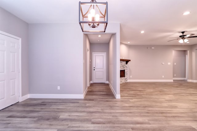 entrance foyer featuring a stone fireplace, recessed lighting, baseboards, and light wood-style floors