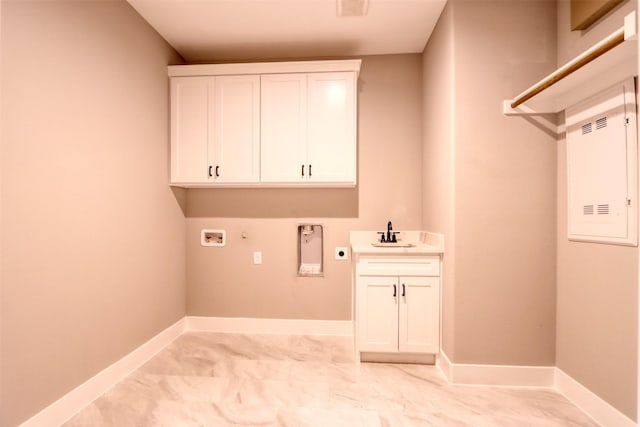 washroom featuring electric dryer hookup, washer hookup, a sink, cabinet space, and baseboards